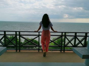 Rear view of woman looking at sea against sky