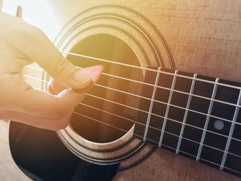 Midsection of man playing guitar