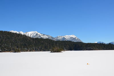 Scenic view of snowcapped mountains against clear blue sky