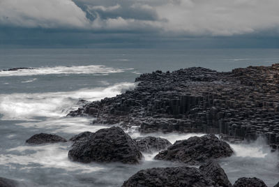 View of rocky beach against clouds