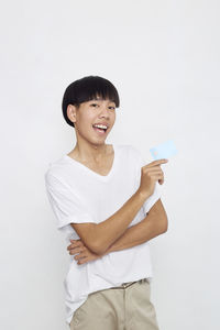 Smiling girl holding umbrella against white background