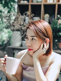 Portrait of young woman looking away outdoors