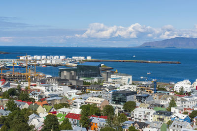 High angle view of city by sea against sky