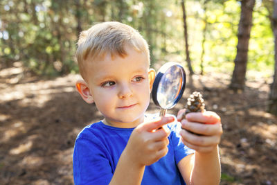 Portrait of young woman blowing bubbles in forest