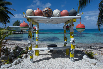 Lounge chairs by swimming pool at beach against sky