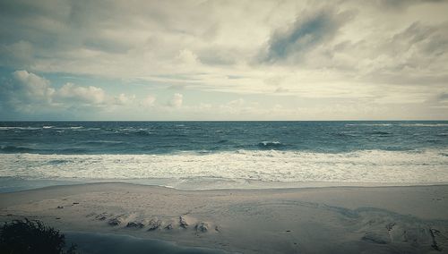 Scenic view of sea against cloudy sky