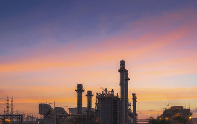 Factory against sky during sunset