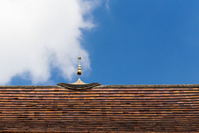 Low angle view of building roof against sky