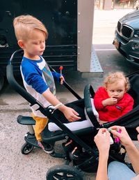 Happy friends sitting by car