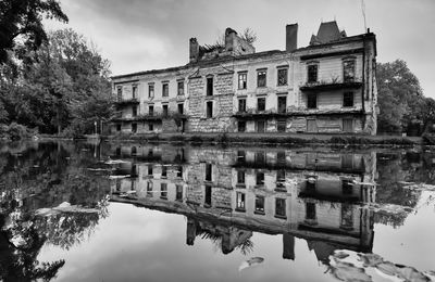 Reflection of buildings on lake against sky