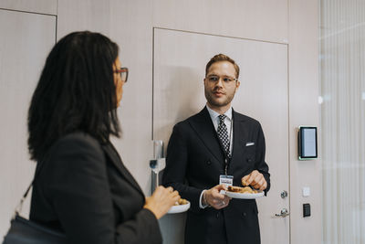 Young businessman with businesswoman discussing during networking event