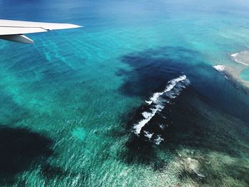 High angle view of aircraft wing against sea