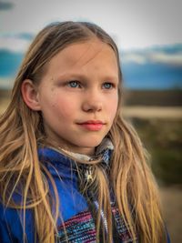 Close-up portrait of girl against sky
