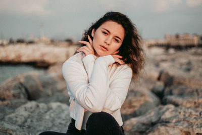 Portrait of young woman sitting on land