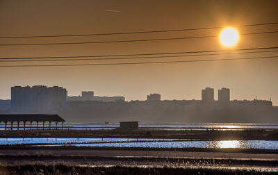 Modern cityscape against sky during sunset