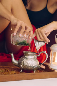 Midsection of woman holding ice cream on table