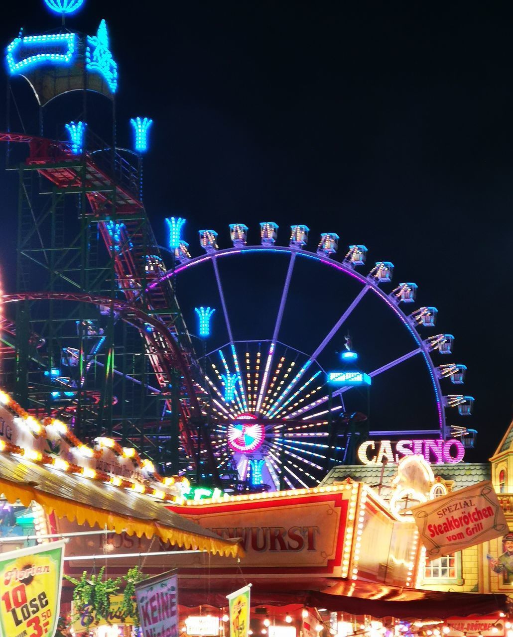 LOW ANGLE VIEW OF ILLUMINATED FERRIS WHEEL AGAINST SKY