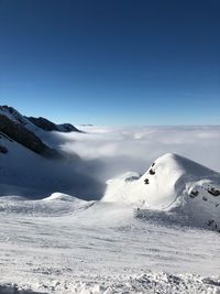 Scenic view of snow covered mountain against blue sky