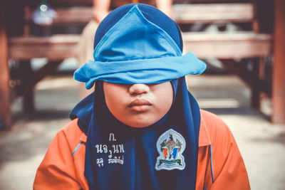 Portrait of boy standing against blue wall