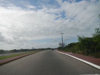 Empty road against cloudy sky