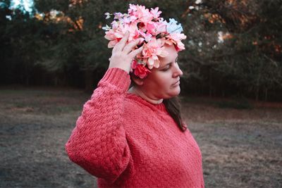 Side view of woman standing against pink flower