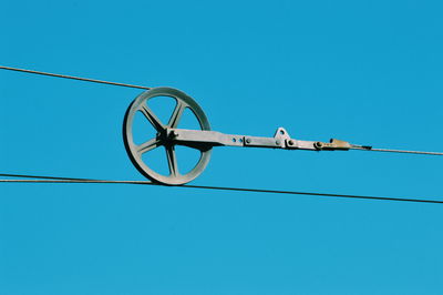 Low angle view of telephone pole against clear blue sky