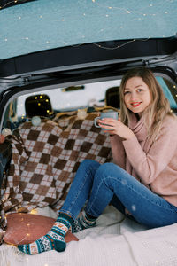 Portrait of young woman sitting in car