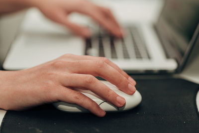Cropped hands of man using laptop