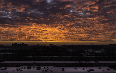 Scenic view of dramatic sky over city during sunset