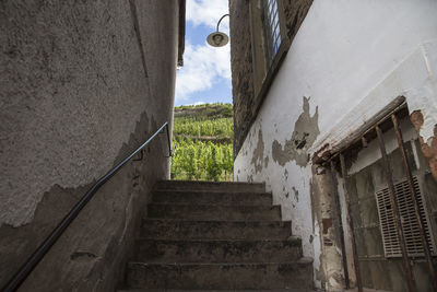 Low angle view of steps amidst old buildings