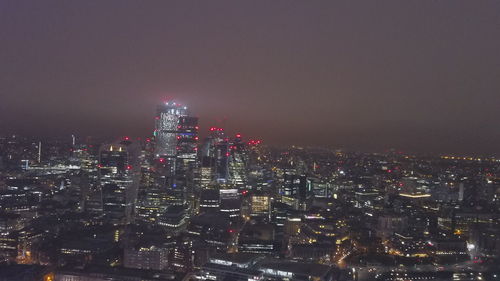 Illuminated cityscape against sky at night