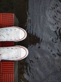 Low section of person standing on steps during rainy season