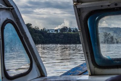 Close-up of boat on river against sky