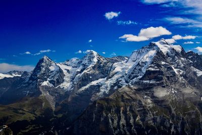 Scenic view of snowcapped mountains against blue sky