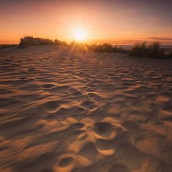 Scenic view of beach against sky during sunset