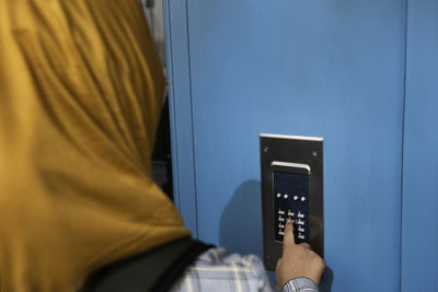 Woman pressing buttons on intercom