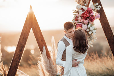 Rear view of couple standing against the wall