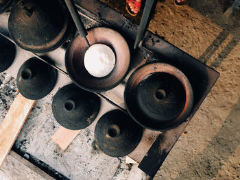 High angle view of surabi, indonesian pancake, cooked upon small earthenware frying pan.