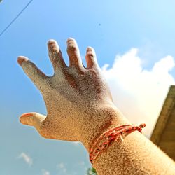 Low angle view of hand against sky