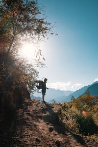 Rear view of man by tree against sky