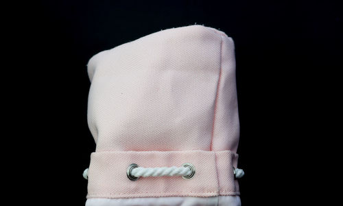 Close-up of hat against black background