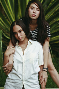 Portrait of young women standing against plants