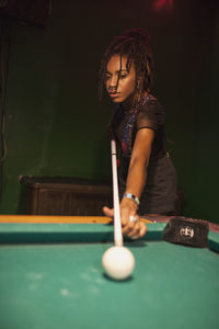 A young woman playing pool.