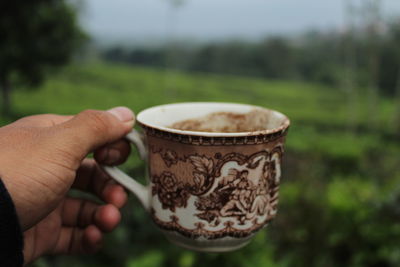 Close-up of hand holding coffee cup
