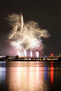 Firework display over river at night