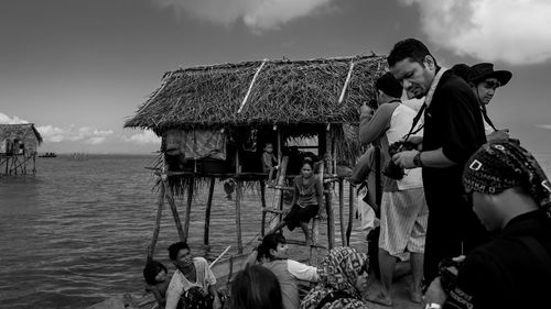 People standing on shore against sky