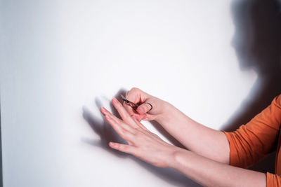Midsection of woman with hands against white background
