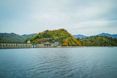 Scenic view of lake by mountain against sky