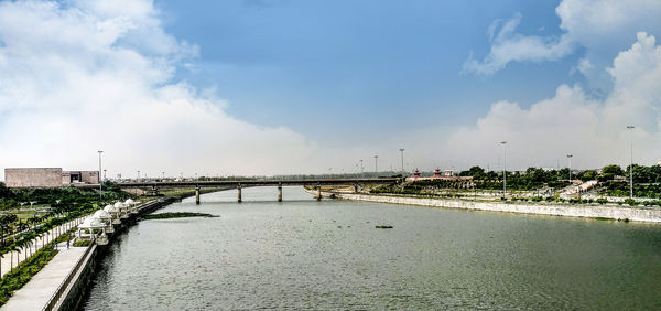 Bridge over river against sky in city