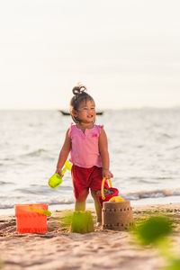 Full length of cute girl standing on beach